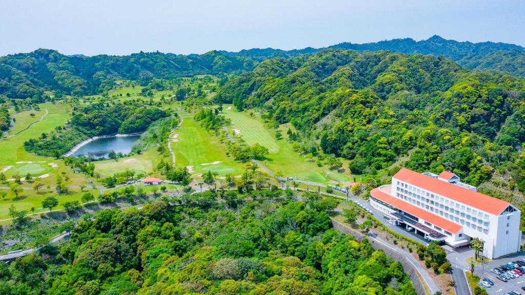 eine Luftansicht auf ein Gebäude und einen Golfplatz in der Unterkunft Kamogawa Country Hotel in Kamogawa
