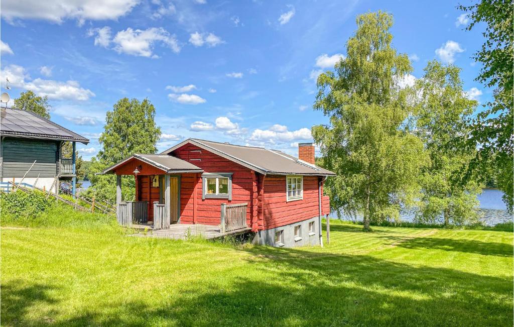 a red house on a grassy hill with a house at Nice Home In Ludvika With House Sea View in Ludvika