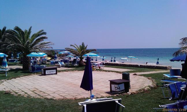 una spiaggia con sedie e ombrelloni e l'oceano di Residence Sabbiachiara a Lido Marini
