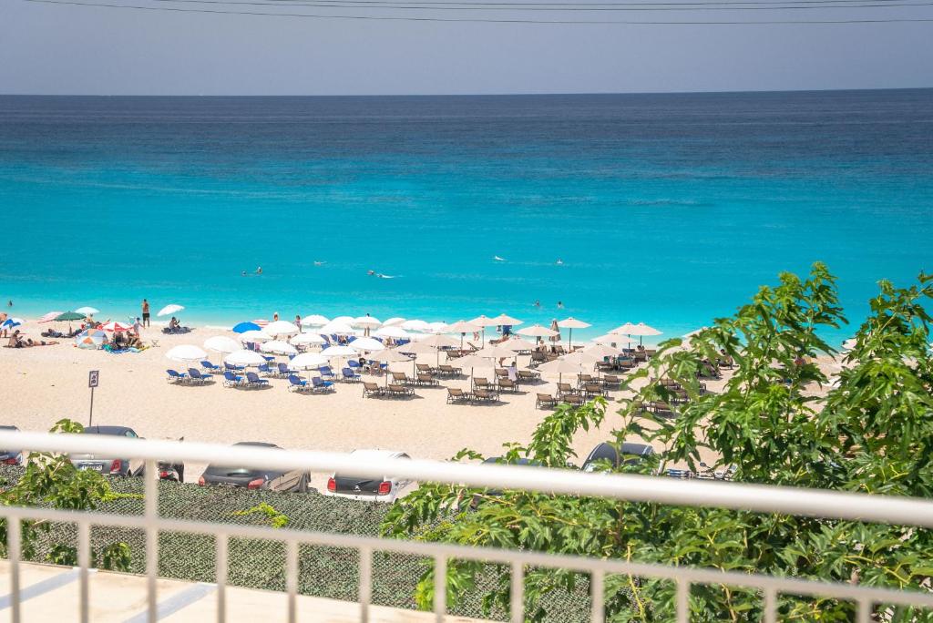 una spiaggia con ombrelloni e sedie e l'oceano di Monato Luxury Apartments a Ayios Nikitas