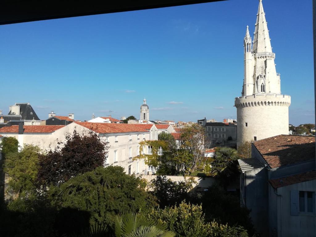 - une vue sur une ville dotée d'une grande tour blanche dans l'établissement Duplex vue sur tour Appartement Remparts 3, à La Rochelle