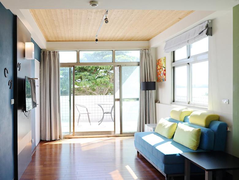 金寧鄉的住宿－微風海戀度假民宿，客厅设有蓝色的沙发和大窗户