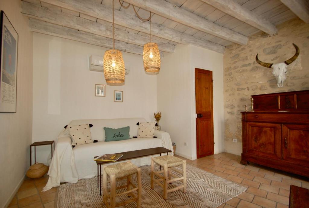 ein Wohnzimmer mit einem Sofa und 2 Hockern in der Unterkunft Rêv'Arles Maison de charmes aux Arènes in Arles