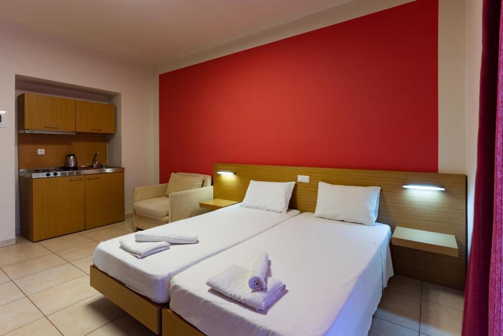 1 dormitorio con cama grande y pared roja en Lia Studios en Pefki Rhodes