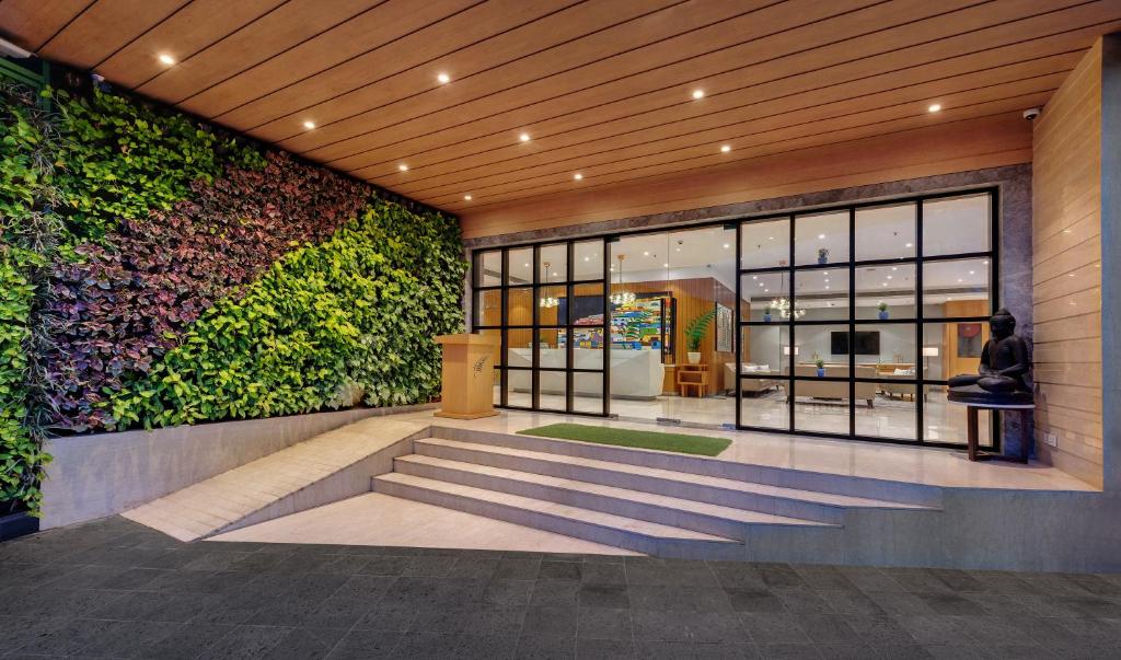 a lobby of a building with a green wall at The Fern Residency Turbhe in Navi Mumbai