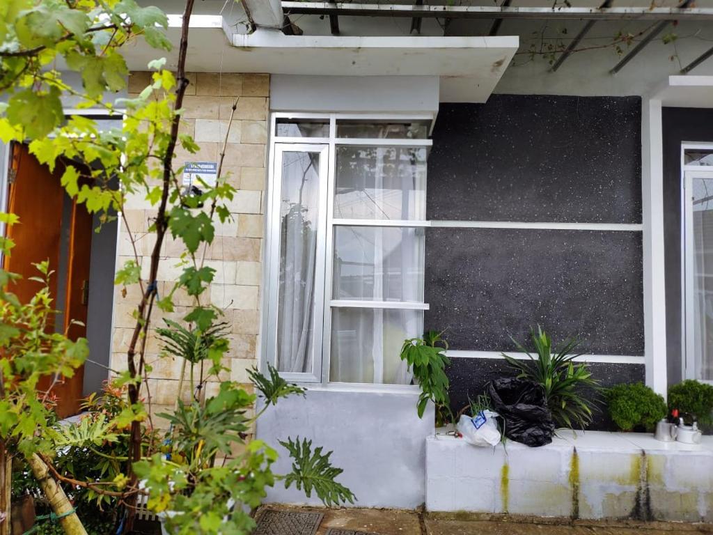 uma casa com uma janela com plantas em frente em Homestay Srikandi em Garut