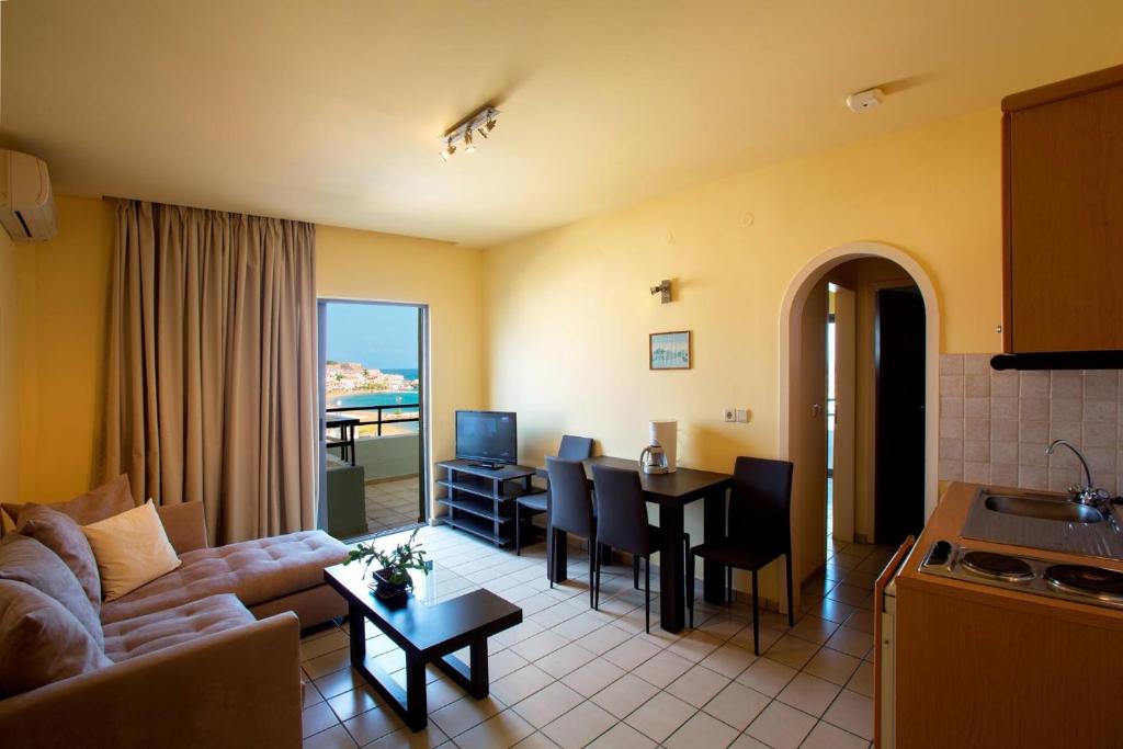 uma sala de estar com um sofá e uma sala de jantar em Jason Hotel Apartments em Rethymno Town