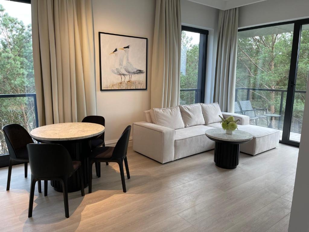 a living room with a white couch and a table at ApartamentyRogowo Com in Rogowo