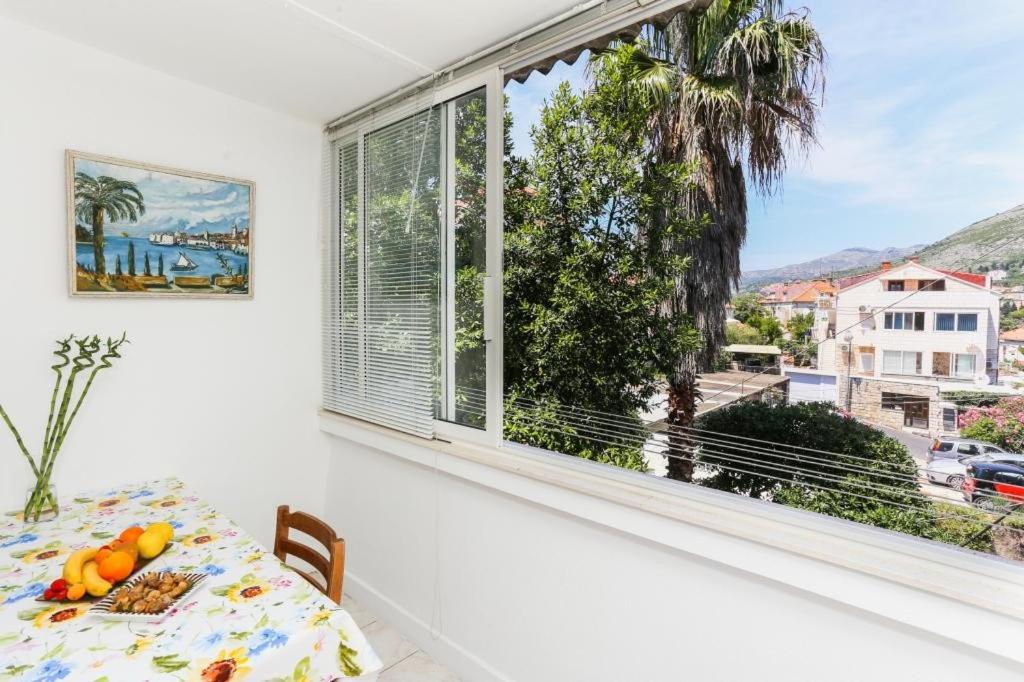 una sala da pranzo con un tavolo e una grande finestra di Apartment Vukoja a Dubrovnik