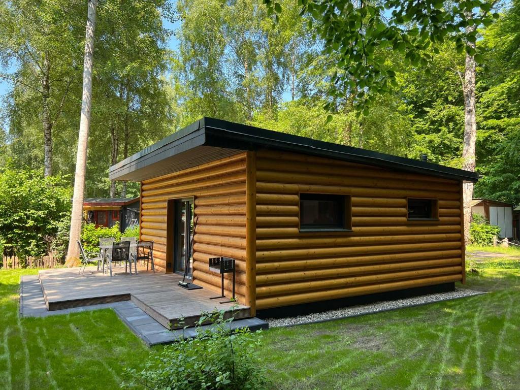 a log cabin with a deck in the grass at Ferienhaus Pepe in Graal-Müritz