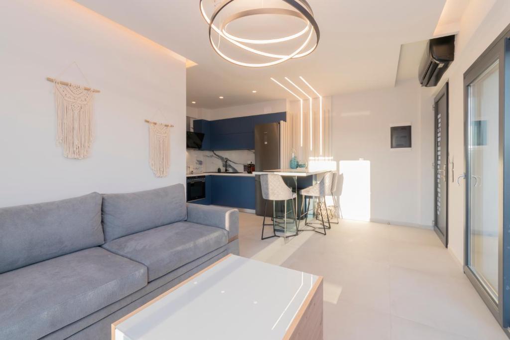 a living room with a couch and a kitchen at SithoniaRS Melora Luxury Apartment in Nikiti