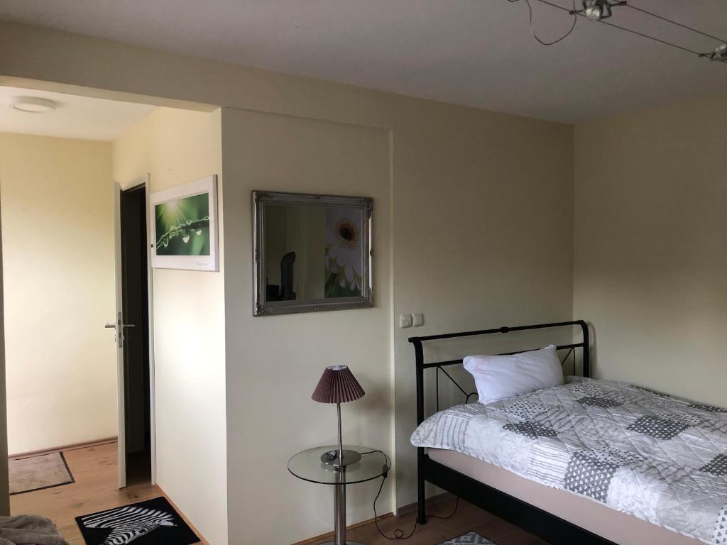 a bedroom with a bed and a mirror and a lamp at Appartment Maggy in Bad Liebenwerda