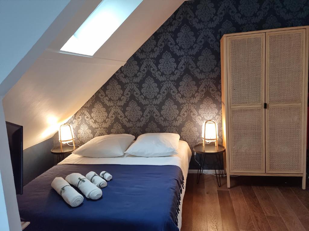 a bedroom with a blue bed with three pillows at Studio Cosy Centre ville in Caen
