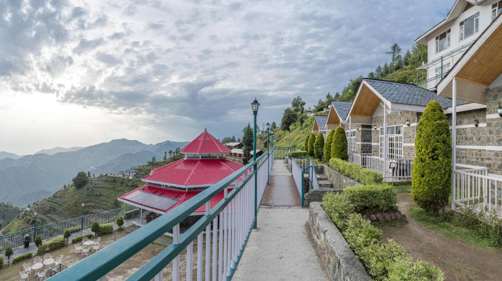 uma varanda de um edifício com um telhado vermelho em Echor - The Koti Village Resort Kufri em Kūfrī