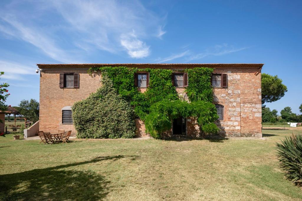 ein Ziegelgebäude mit Efeu, der darauf wächst in der Unterkunft Quercesecca in Marina di Grosseto