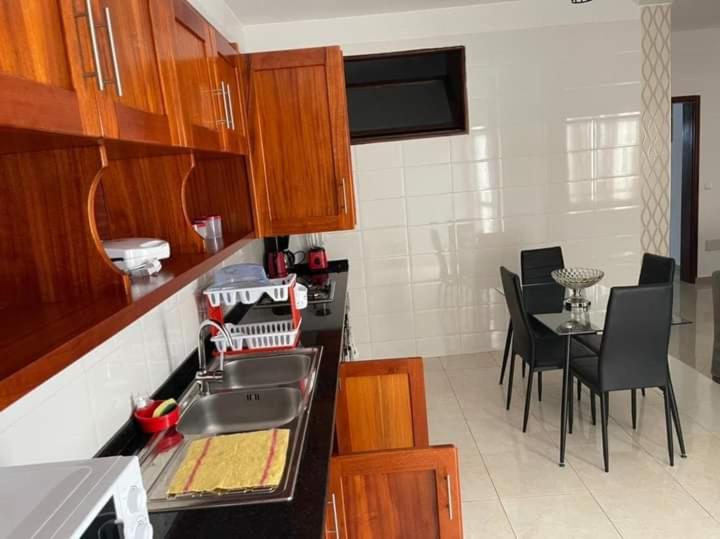 a kitchen with a sink and a table with chairs at Casa Kyara Apart T2 in Praia