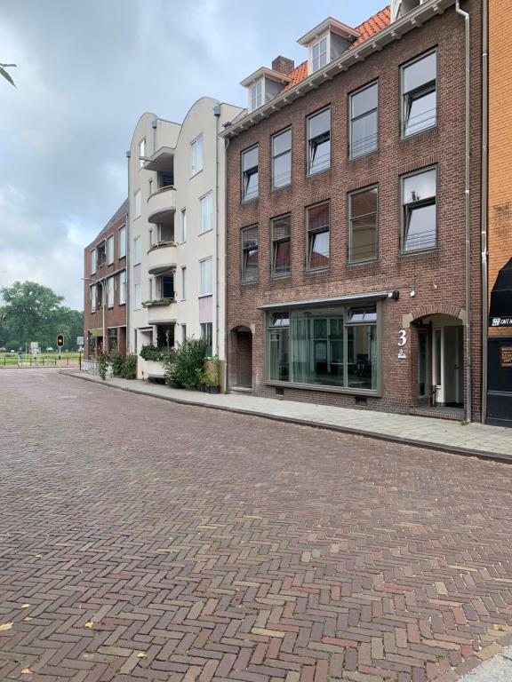 an empty street with buildings and a brick road at Stadshotel aan de IJssel in hartje Deventer in Deventer