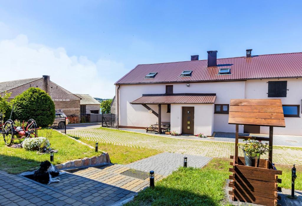 a couple sitting on a patio in front of a house at Agroturystyka Piechowscy in Lipnica