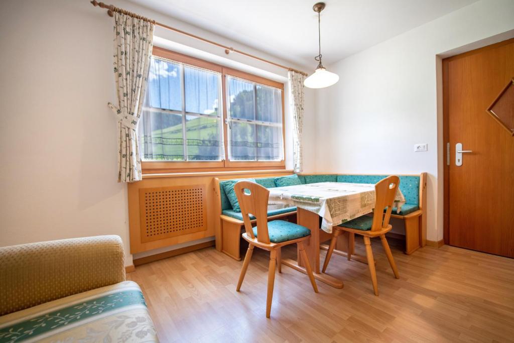 a dining room with a table and chairs and a window at Apartments Berdan in Santa Cristina Gherdëina