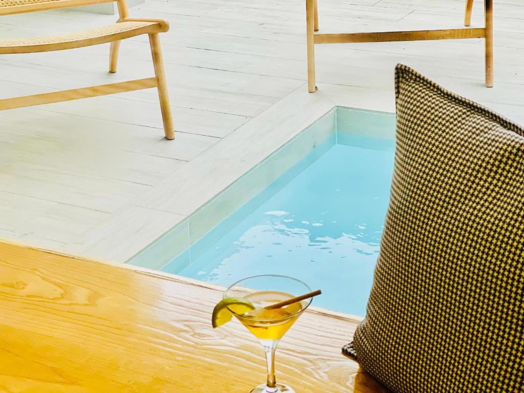 a glass of wine sitting next to a swimming pool at Canaryislandshost l Boya Suites in Playa Honda
