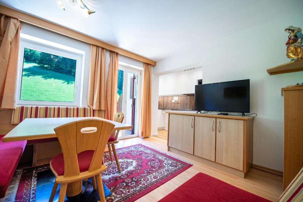 salon ze stołem i telewizorem w obiekcie Apartments Seida w mieście Selva di Val Gardena