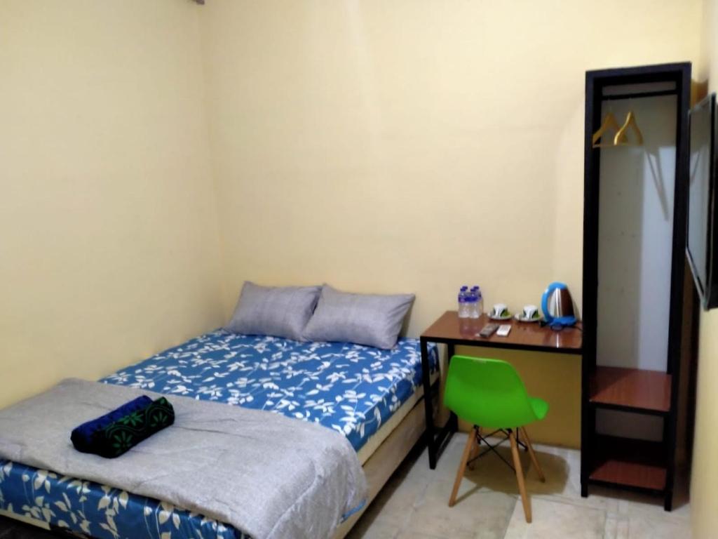 a bedroom with a bed and a desk and a chair at SPOT ON 91402 Home'59 Tegal Danas in Bekasi