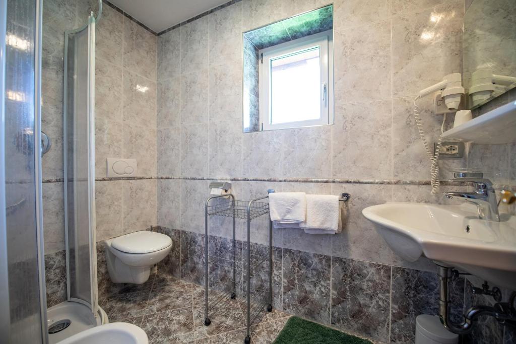 łazienka z toaletą i umywalką w obiekcie Apartments Seida w mieście Selva di Val Gardena