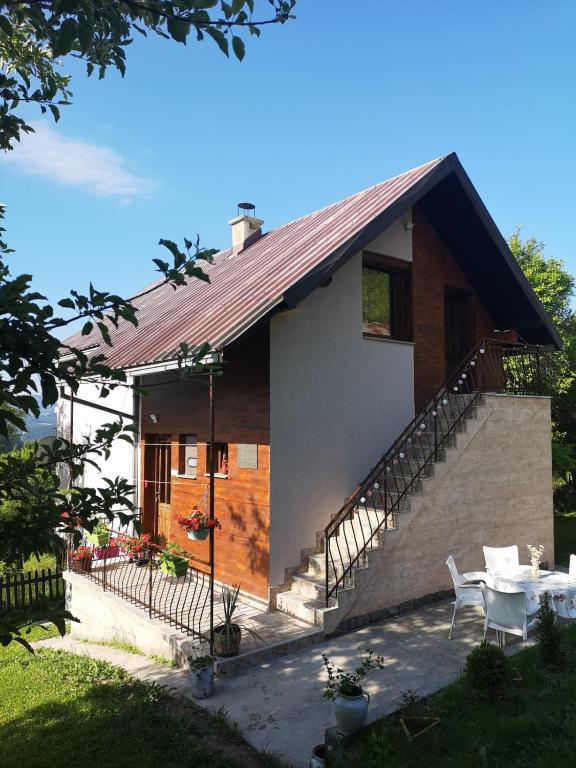 a house with a staircase and a table and chairs at Seoska kuća Jela in Nova Varoš