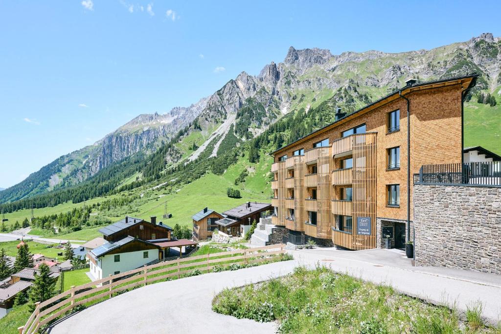 un edificio con una montaña en el fondo en 1400 FlexenLodge en Stuben am Arlberg
