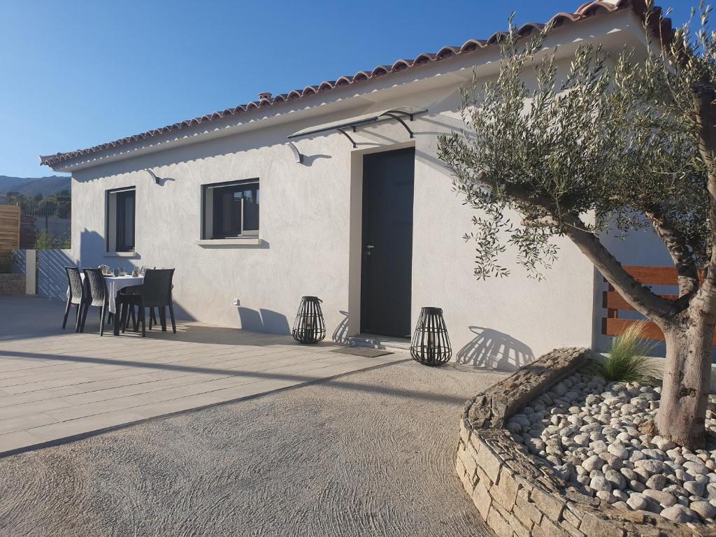 une maison avec une table et des chaises devant elle dans l'établissement Villa l'alivu, à Afa