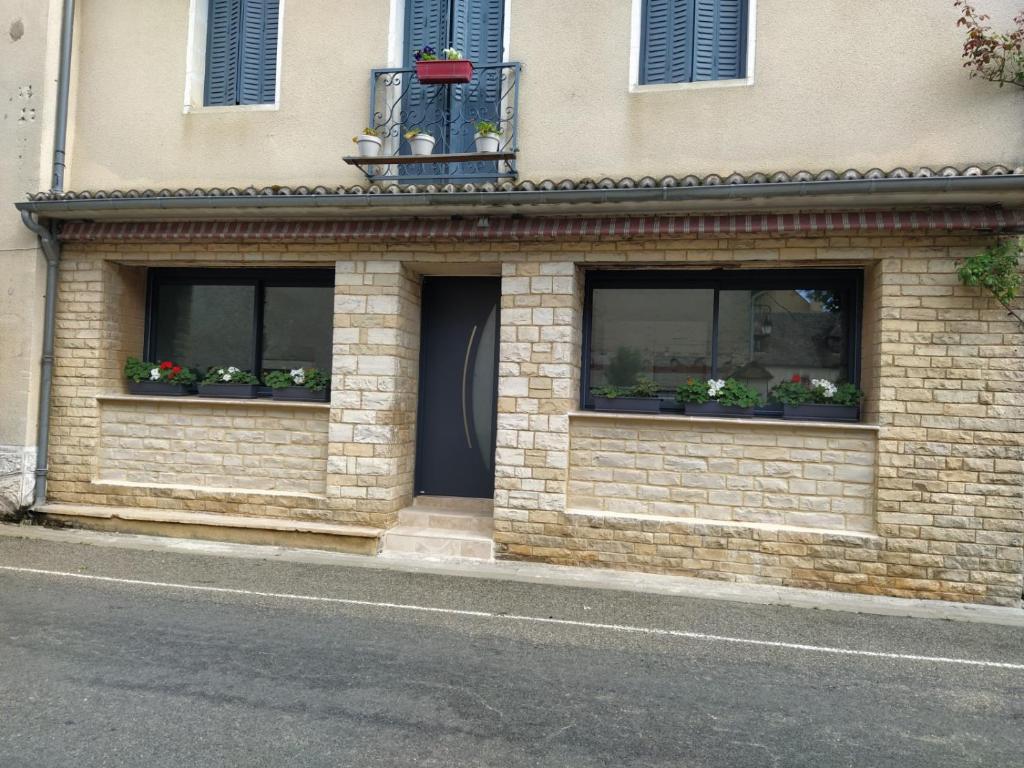 a building with two windows with flowers in them at Appartement moderne dans village de charme in Salviac