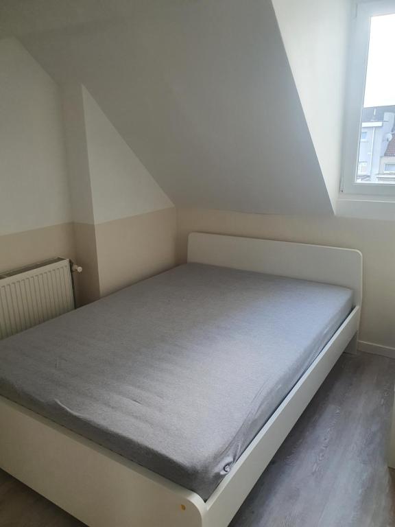a bed in a small room with a window at B96 appart 2 bedrooms in Brussels