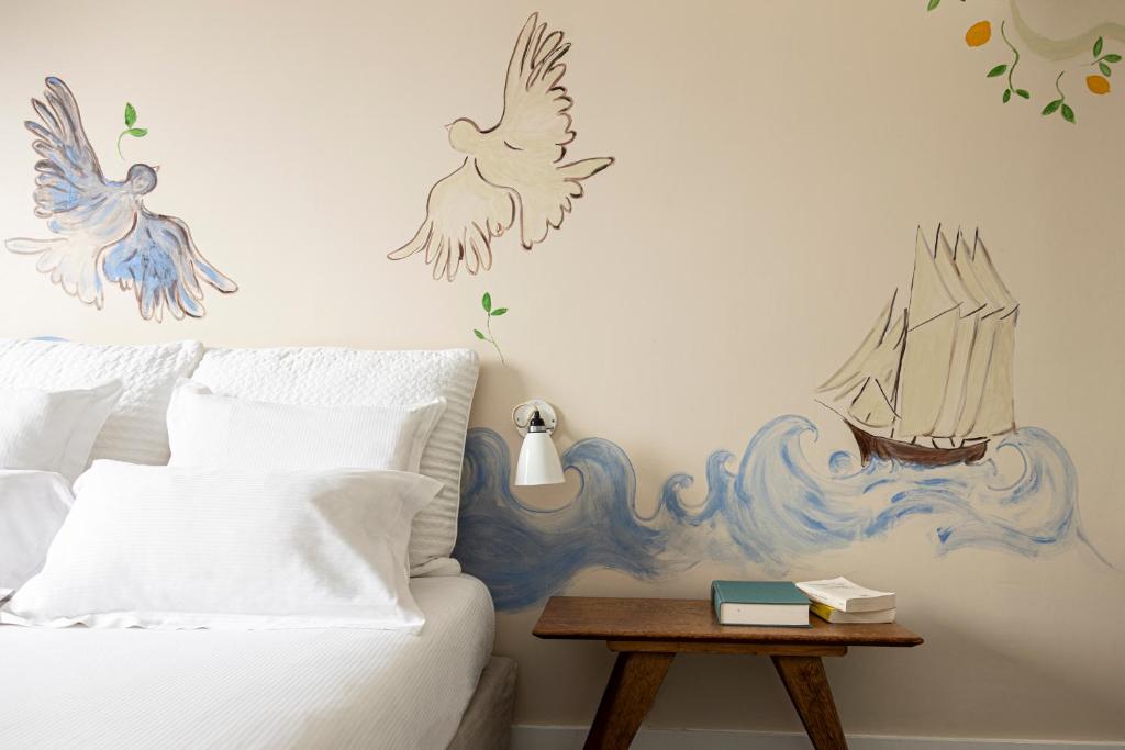 パリにあるオテル アルヴォル サン ジョルジュのベッドルーム1室(壁に鳥が描かれたベッド1台付)