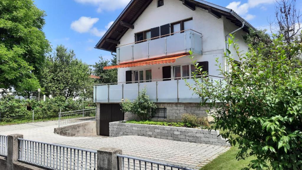 a white house with a fence in front of it at Green Hill Apartments - Dornbirn in Dornbirn