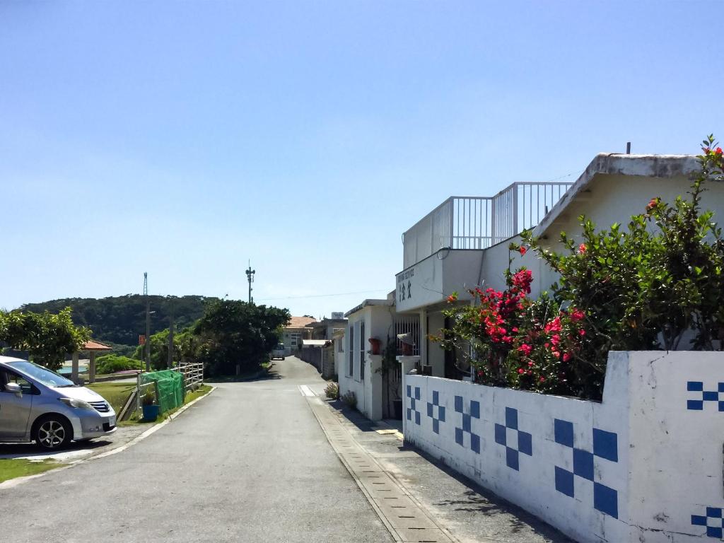 a street with a building and a car parked on the side at Housei in Zamami