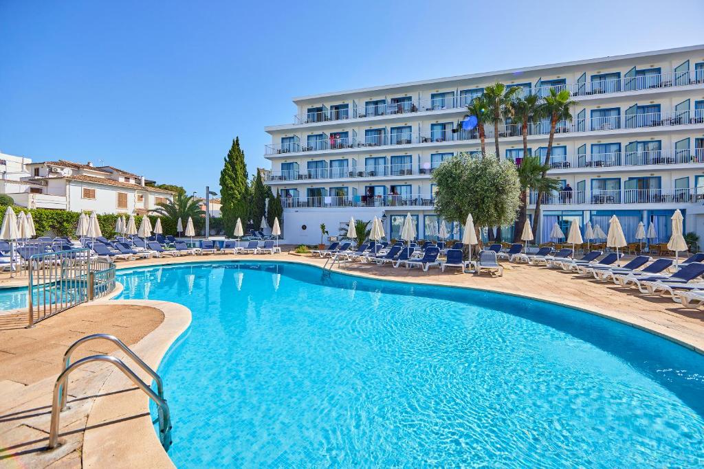 une piscine en face d'un hôtel dans l'établissement Ilusion Vista Blava, à Cala Millor