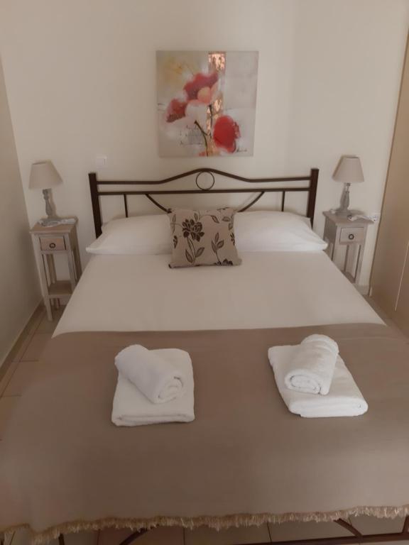 un grande letto con due asciugamani bianchi sopra di Cosy Studio a Sitia