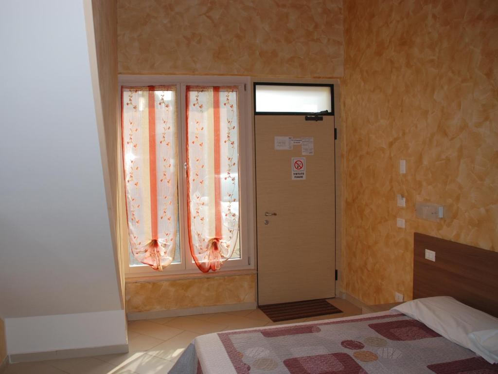 um quarto com uma cama e uma janela com cortinas em Affittacamere Matteo em Verona