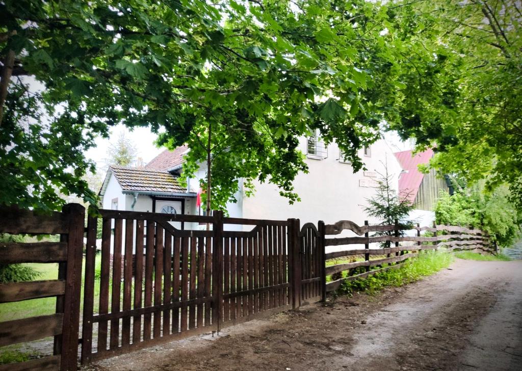 einen Holzzaun vor einem weißen Haus in der Unterkunft Dom z Charyzmą na Mazurach in Miłki