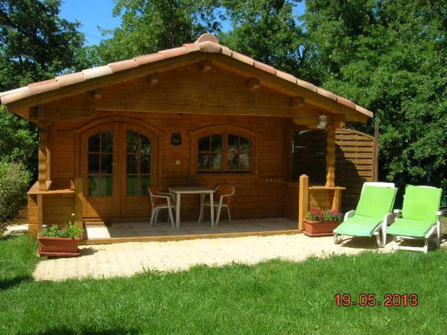 a small log cabin with a table and chairs at Chalet l'emiline , Gite climatisé au sud d'aix avec piscine in Bouc-Bel-Air