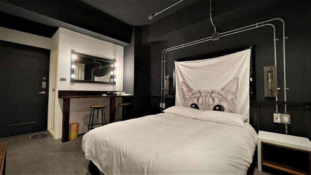 Un dormitorio con una cama blanca con cara de gato. en Sky Tree B&B en Taichung