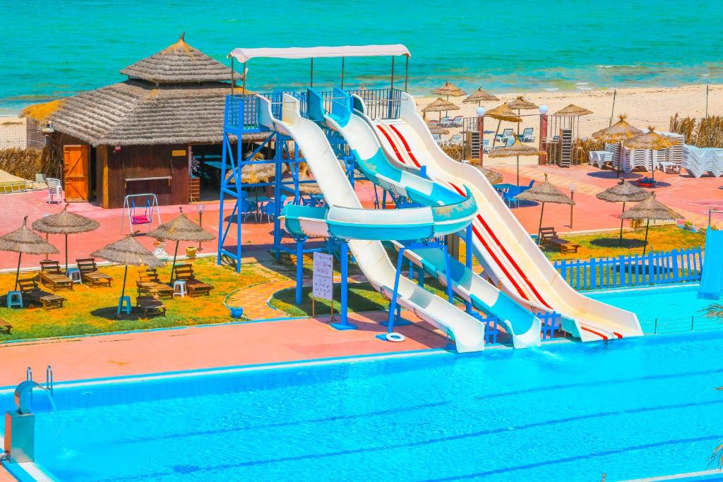 un tobogán de agua en una piscina de un complejo en Hotel Neptunia Skanes, en Monastir