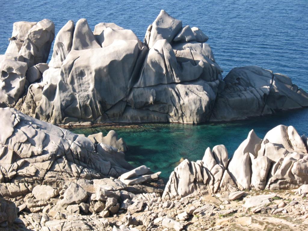 un gruppo di rocce nell'acqua di Hotel San Trano a Luogosanto