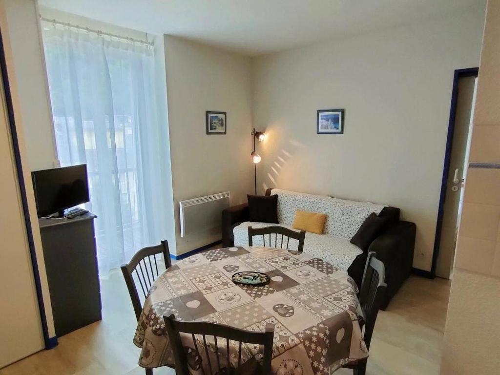 a living room with a table and a couch at Appartement Cauterets, 2 pièces, 4 personnes - FR-1-234-93 in Cauterets