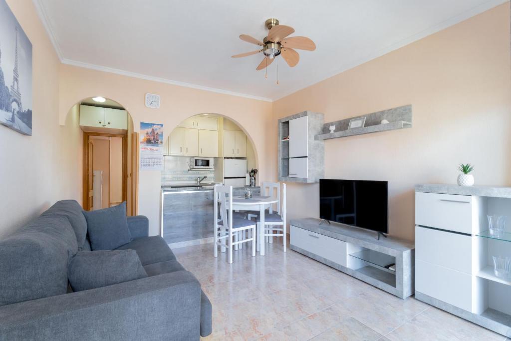 ein Wohnzimmer mit einem Sofa und einer Küche in der Unterkunft MI PERLA in Torrevieja