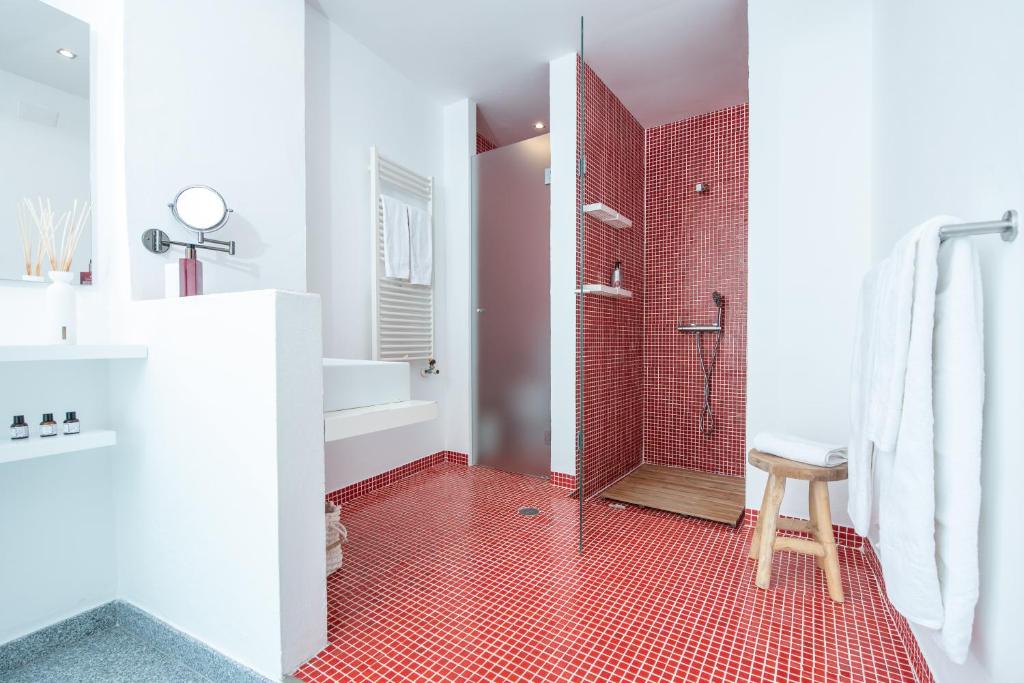 baño con ducha y suelo de baldosa roja. en Casa D`Arronches en Arronches