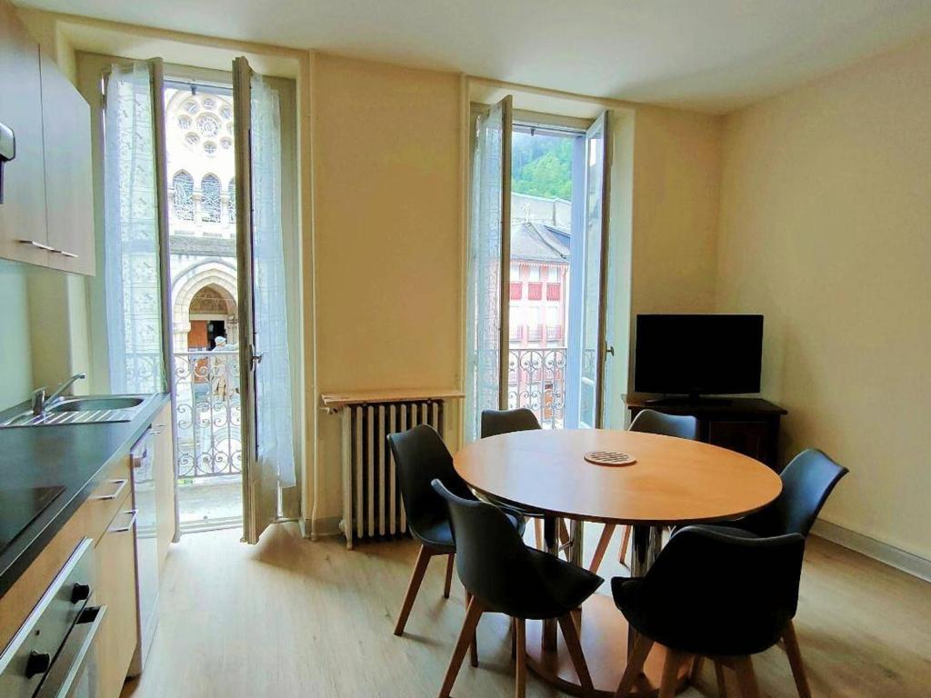 una cucina con tavolo e sedie in una stanza di Appartement Cauterets, 3 pièces, 6 personnes - FR-1-234-142 a Cauterets