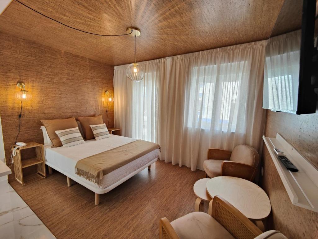 um quarto com uma cama e uma televisão num quarto em Corkoon Boutique Studios & Apartments - Duna Parque Group em Vila Nova de Milfontes