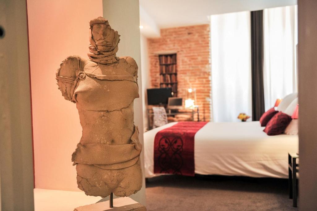 une statue dans une chambre d'hôtel avec un lit dans l'établissement Hôtel des Arts, à Toulouse