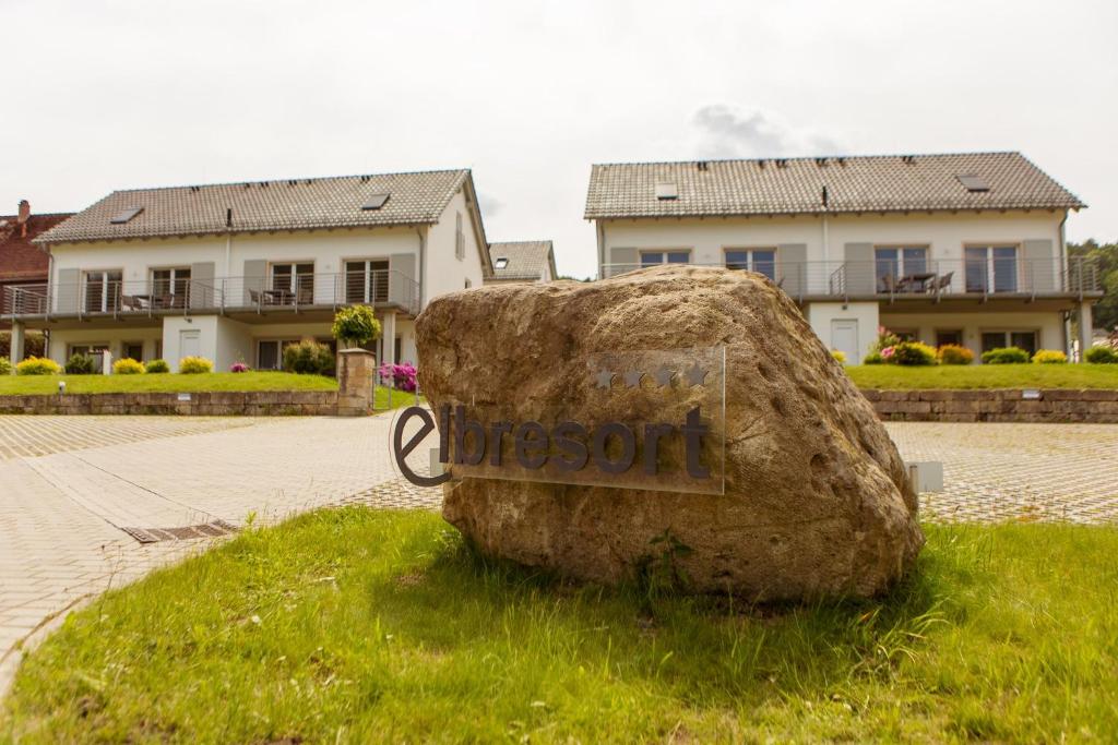 a rock sitting in the grass in front of a house at Elbresort Kurort Rathen in Rathen